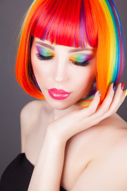 belle femme portant une perruque colorée et montrant des ongles colorés
  - Photo, image