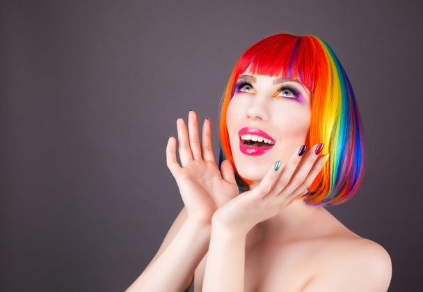 piękna kobieta nosi kolorowe peruki i przedstawienie kolorowe paznokcie  - Zdjęcie, obraz