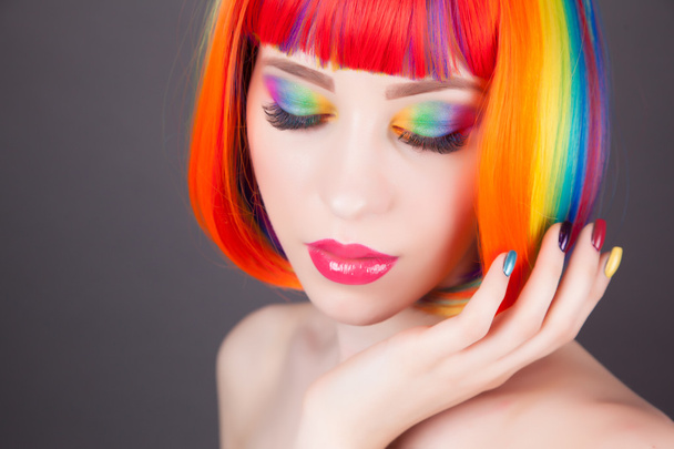красива жінка в барвистій перуці і показує барвисті нігті
  - Фото, зображення
