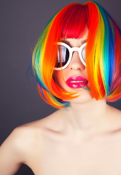 beautiful woman wearing colorful wig and white sunglasses - Foto, Imagen