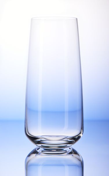 Empty drinking glass on white and blue background  - Фото, изображение