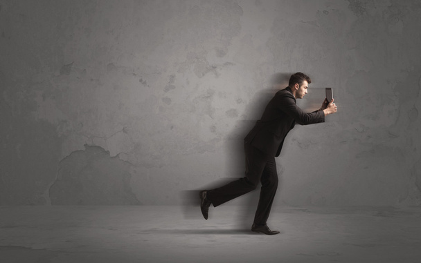 Running businessman with device in hand - Photo, Image