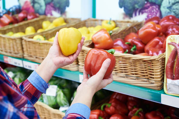 Buyer selects bell peppers in store - Φωτογραφία, εικόνα