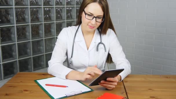 Γυναίκα γιατρό χρησιμοποιώντας tablet pc στο γραφείο - Πλάνα, βίντεο
