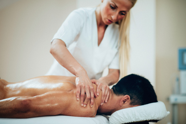 Massagetherapeutin macht Schultermassage - Foto, Bild