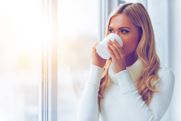 woman in white sweater drinking coffee - Foto, immagini