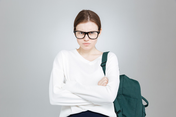Angry pretty girl student in glasses with backpack  - Fotografie, Obrázek