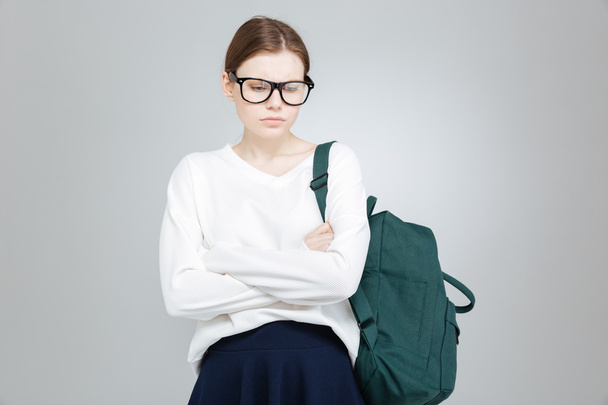 Sad depressed girl student in glasses standing with hands folded  - Foto, afbeelding
