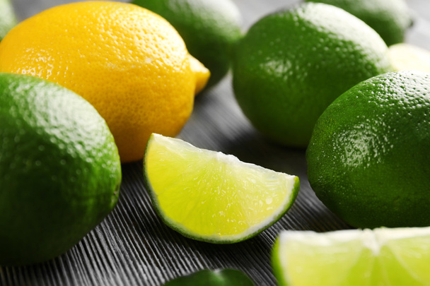 Limes and slices on wooden table, closeup - Foto, imagen