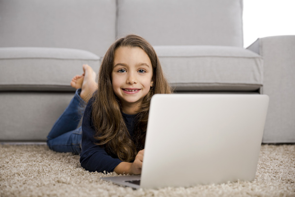 Little girl working with a laptop - Foto, imagen