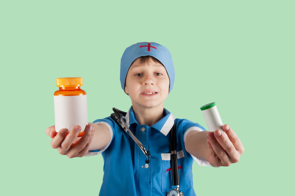 jeune garçon en costume de médecin montrant bouteilles de pilule
 - Photo, image