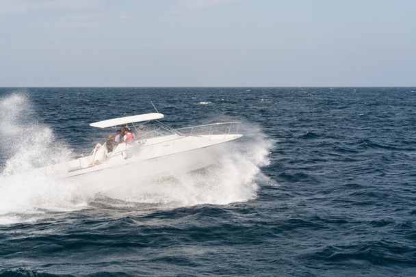 Белый моторный катер плывет по волнам
 - Фото, изображение
