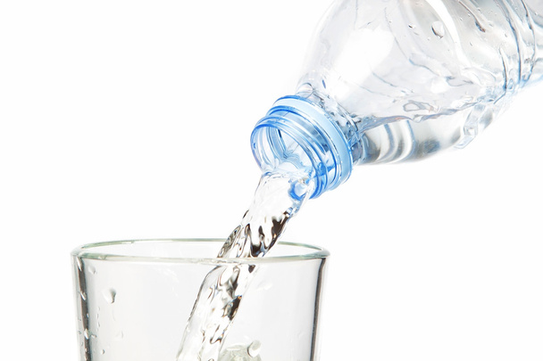 Clean water flowing into the bottle. On a white background. - Foto, afbeelding