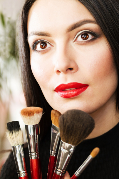 beautiful young brunette woman doing makeup - Фото, изображение