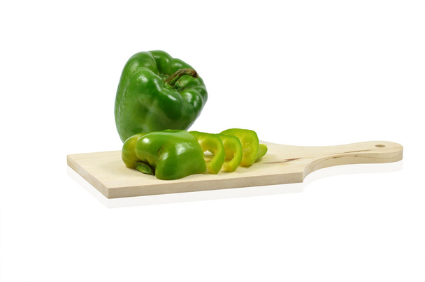 zelené papriky nakrájené na dřevěné prkénko  - Fotografie, Obrázek