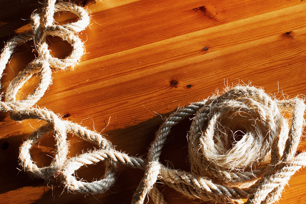 Imagen vintage tonificada de la cuerda del barco grande hank en el fondo de una mesa de madera marrón
. - Foto, Imagen