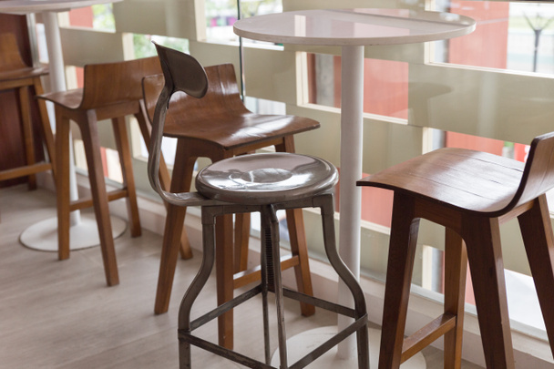μεταλλικά και ξύλινα σκαμπό με στρογγυλό τραπέζι στο μπαλκόνι - Φωτογραφία, εικόνα