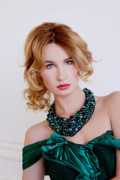 Shapely blond woman in green restoration evening gown and neckla - 写真・画像