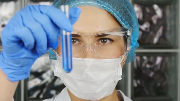Um cientista olha para uma amostra de um produto químico em um laboratório
 - Filmagem, Vídeo