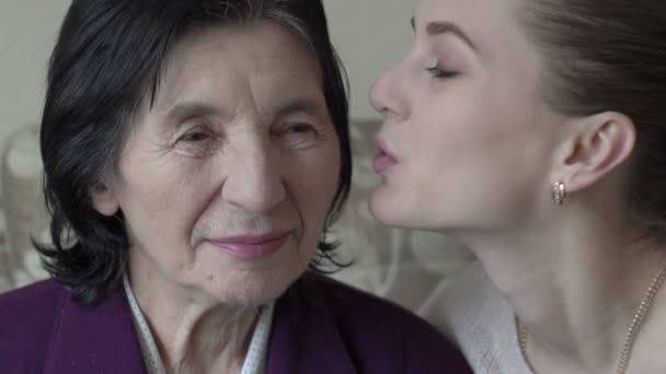 Granddaughter kissing and embracing grandma. Slowly - Materiał filmowy, wideo