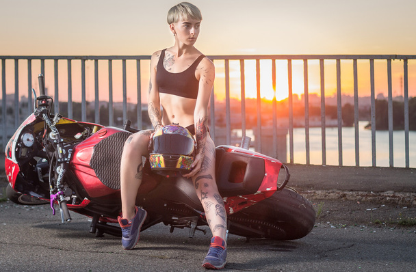 Дівчина з татуюваннями сидить на мотоциклі
 - Фото, зображення