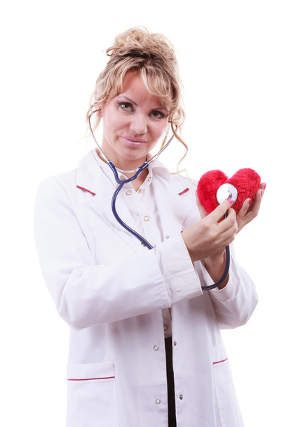 Doctor with stethoscope examining red heart. - Fotoğraf, Görsel