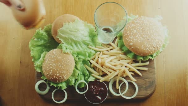 Χάμπουργκερ ένα σάντουιτς και γαλλικές πατάτες σε μια σχάρα - Πλάνα, βίντεο