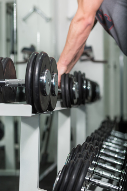 Closeup of a muscular young man lifting weights, Caucasian man - Φωτογραφία, εικόνα