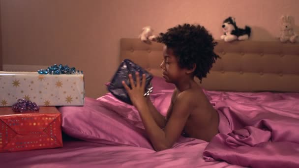Sötét bőrű kis fiú örül az ajándékok. - Felvétel, videó
