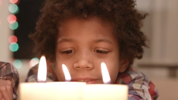 Smiling boy looks at candle. - Footage, Video
