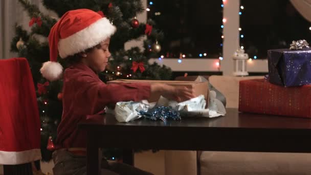 黒の少年はクリスマス プレゼントを開く. - 映像、動画