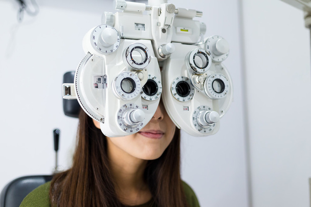Γυναίκα που κάνει δοκιμή μάτι στο οπτικό κλινική - Φωτογραφία, εικόνα