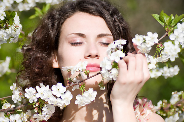 Hermosa mujer en flores de primavera
 - Foto, imagen