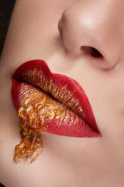 Close up lips with red and gold make up - 写真・画像