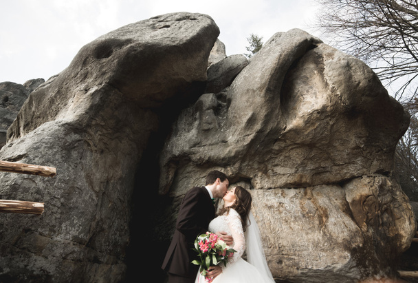 Happy wedding couple kissing and hugging near a high cliff - Φωτογραφία, εικόνα