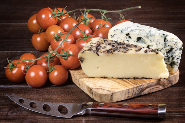 Cheese and tomatoes on the wooden desk - Фото, изображение