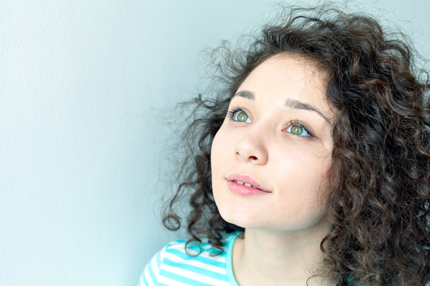Portrait of a beautiful young girl with curly hair. Big green eyes and eyelashes closeup. Lookup - Foto, imagen