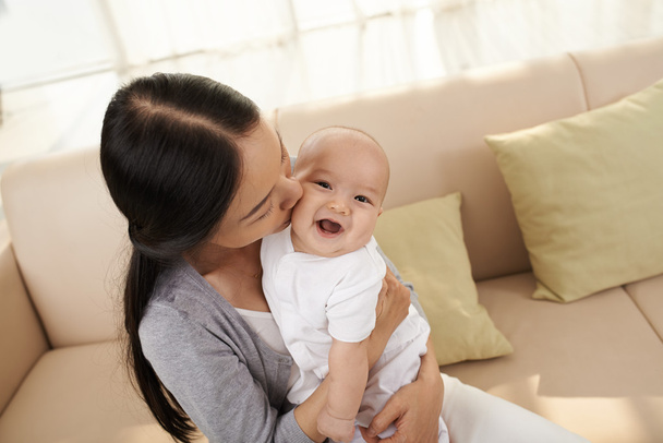 Kobieta całuje swoje dziecko  - Zdjęcie, obraz
