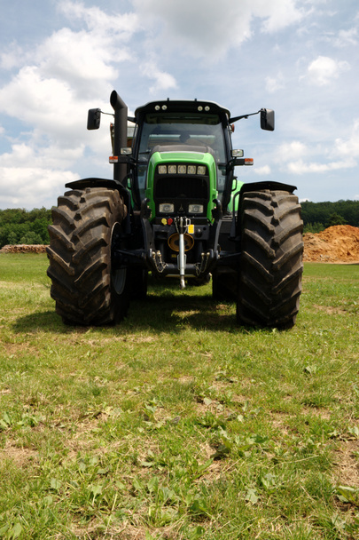 Зеленый трактор на траве
 - Фото, изображение