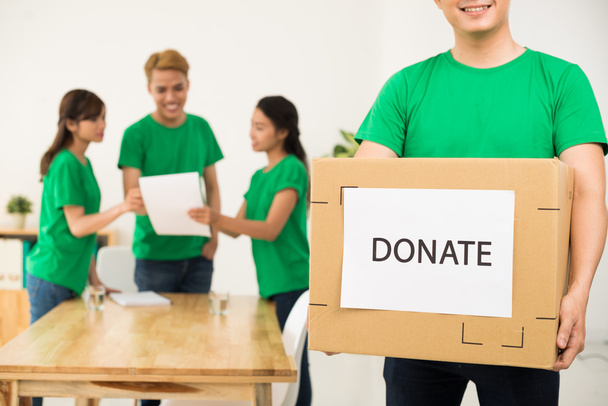 Добровольцы упаковывают коробки для пожертвований - Фото, изображение