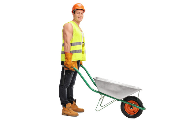 Worker posing with an empty wheelbarrow  - Фото, зображення