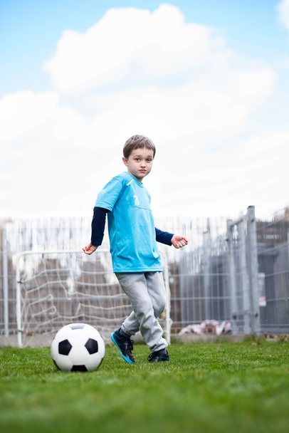 7 years boy kicking ball in the garden. - Foto, immagini