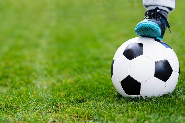 Stopy dziecka na piłki nożnej / piłki nożnej na trawie. - Zdjęcie, obraz