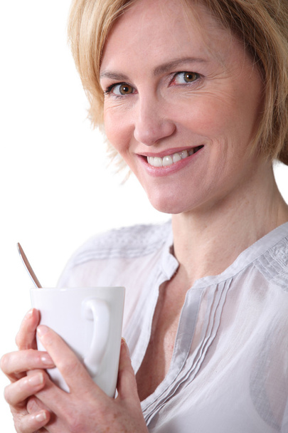 Woman smiling with a cup of tea. - Fotografie, Obrázek