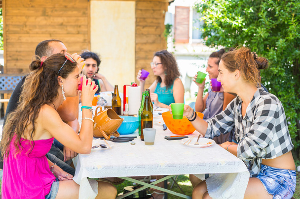 Группа людей, сидящих за обедом вместе и пьющих
 - Фото, изображение