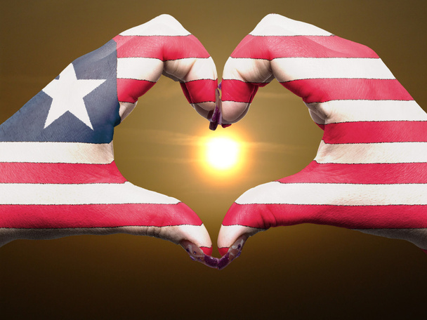 καρδιά και αγάπη χειρονομία από χέρια χρωματισμένη με σημαία Λιβερίας κατά τη διάρκεια του β - Φωτογραφία, εικόνα