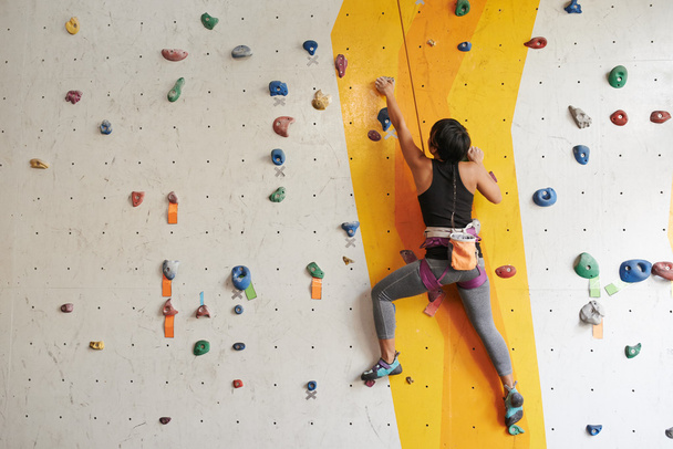 Woman climbing up the wall - Photo, Image