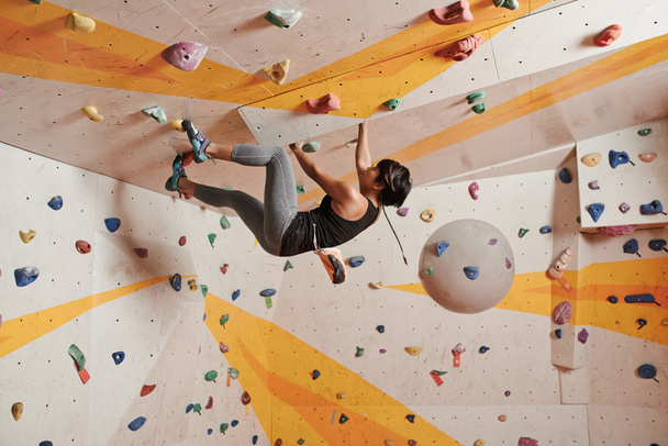 Woman climbing up the wall - Photo, Image