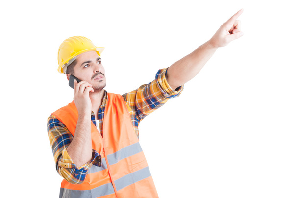 Attractive engineer pointing finger upwards while using cellphon - Φωτογραφία, εικόνα