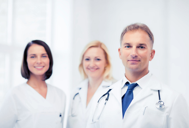 doctor with stethoscope and colleagues - Foto, Bild